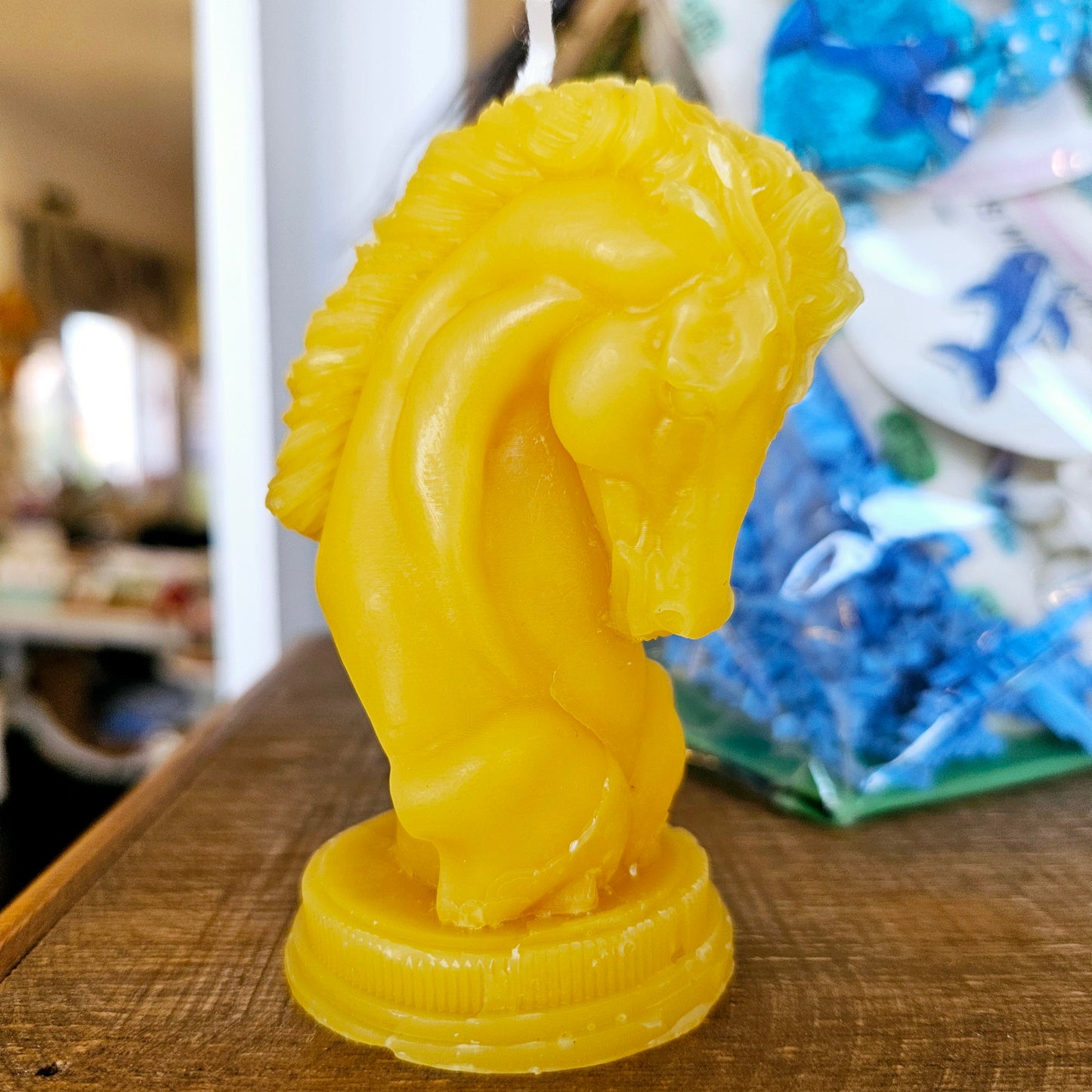 Chess-style horse head beeswax candle on a wood surface