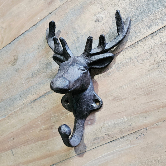 Cast iron deer head wall hook on a wooden surface